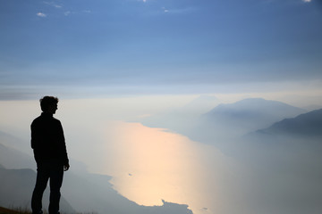 man watching garda lake from monte baldo