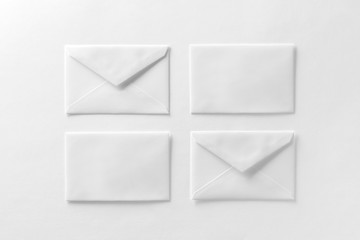 Mockup of four envelopes at white textured paper background.