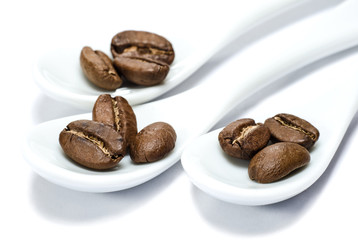 Сoffee beans in porcelain spoons