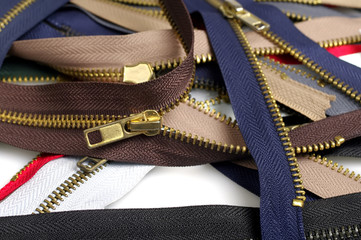 Metallic jeans zippers on white background