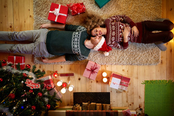 Man and woman lying on the floor for Christmas, top view
