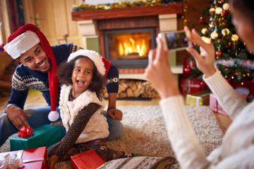 Happy little girl posing her mom for Christmas photo