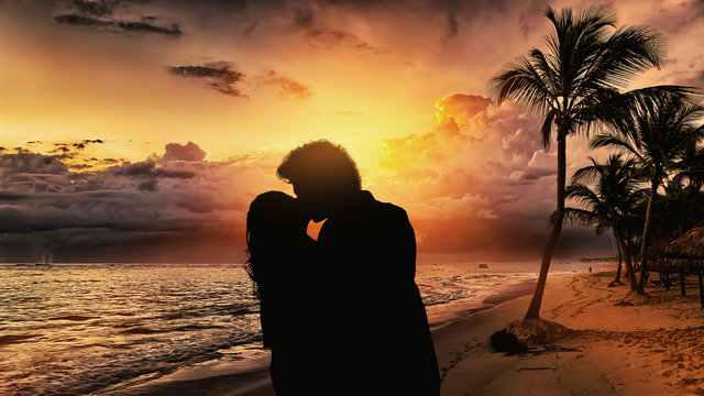 Silhouette di una coppia che si bacia in spiaggia al tramonto