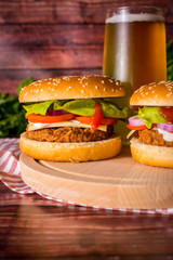 Hamburger and beer on wooden board