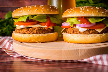 Hamburger and beer on wooden board
