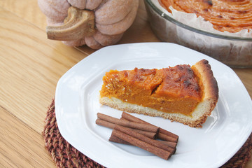 Fetta di torta alla zucca con cannella su piatto su tavolo di legno. Dolce per il giorno del Ringraziamento.