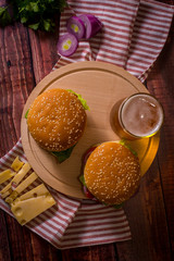 Hamburger and beer on wooden board