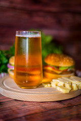 Hamburger and beer on wooden board