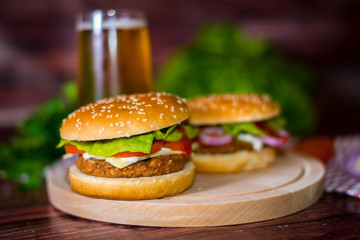 Hamburger and beer on wooden board