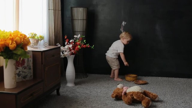Little boy draw a chalk ona blackboard. Cute child with white hair have fun painting.