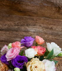 Pink, white and violet eustoma fresh flowers on aged wooden background