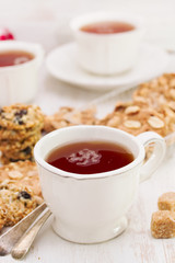 a cup of tea with healthy cookies on white wooden background