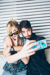 Young couple at cafe taking selfie