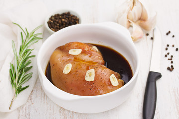 raw chicken in sauce on white bowl