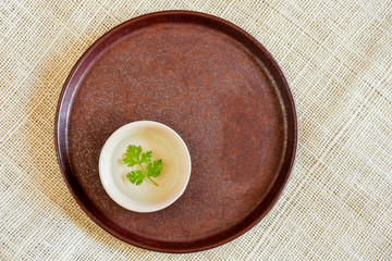 Coriander leaves floating in white cup with water. The leaves take main role in cooking Thai food.