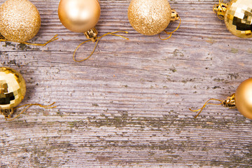 Gold christmas balls on a wooden background