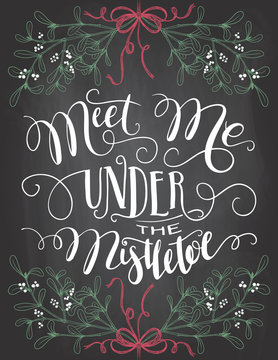 Meet me under the mistletoe. Brush calligraphy on blackboard background with chalk. Christmas chalkboard typography