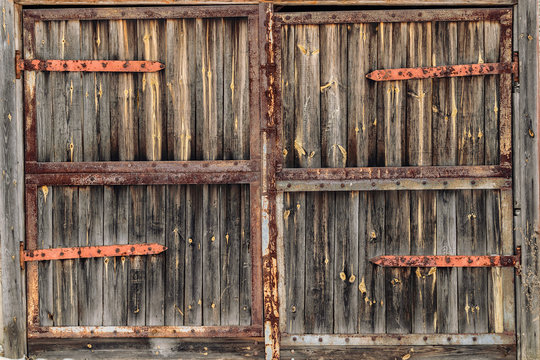 Old wooden door with rusty hinges