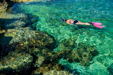 Schöne Frau im Bikini Schnorchelt durch Türkises Wasser an der Küste