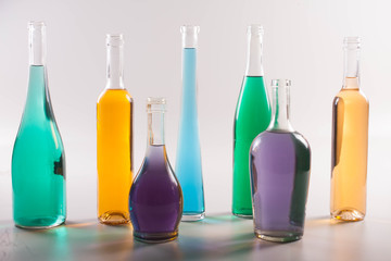 garrafas e copos coloridos em fundo branco