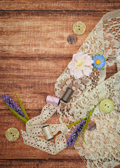 Lace and thread on wooden background