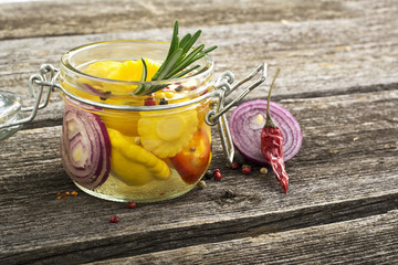 Canned colorful different vegetables Assorted  glass jar with spices, oil, vinegar, salt and sugar in a simple dark wooden background.