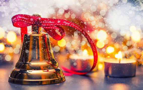 Christmas. Christmas bell with red ribbon candles and snowy background. Happy christmas text.