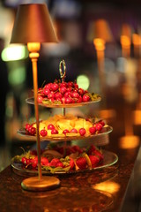 Fototapeta na wymiar Three tiered tray with fruits. Close up. Blurred background