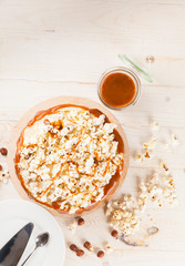 Homemade cake with hazelnuts and salty caramel with vanilla - hazel shortcakes and delicate hazelnut cream, decorated with salty popcorn. Top view.