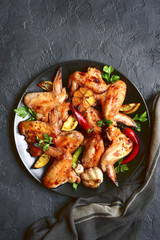 Grilled chicken wings on a black plate.Top view.