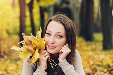 Autumn girl playing in city park. Fall woman portrait of happy lovely and beautiful young woman in forest in fall colors.