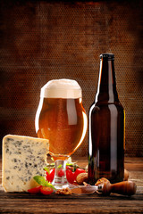 Blue cheese appetizer and beer on brown vintage background