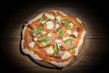 Rustic homemade pizza with figs in dark