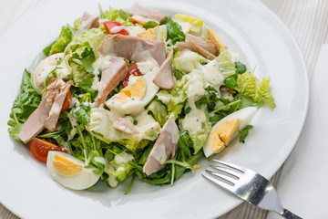 Nutritious vegetable salad with boiled egg slices and salmon