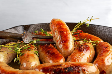 Home-made Pork Sausages in rustic pan with thyme