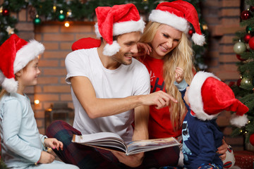 Smiling family looking at book