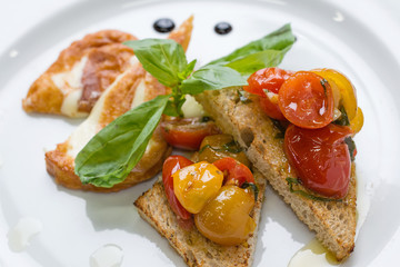 Delicious toast sandwiches with fried cheese, tomatoes, olive oil and basil