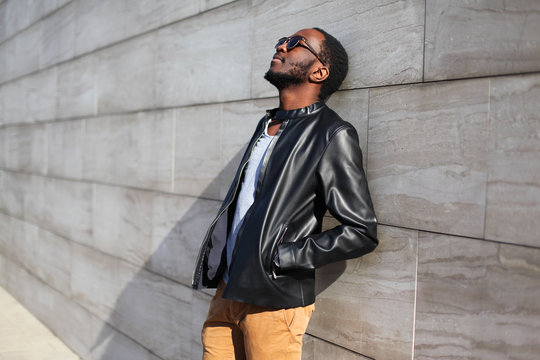 Fashion african man relaxing in the city over gray background