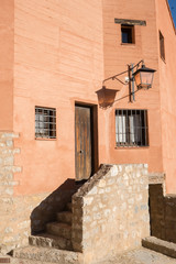 Fototapeta na wymiar Casa junto a una escalera en un pueblo antiguo español con un farol 