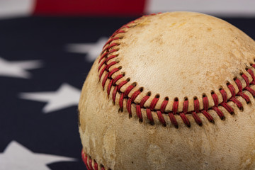 Baseball, America's game.  An old weathered baseball on an American flag. 