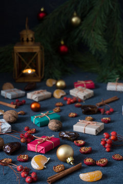 Christmas gifts, rowan, nuts, old lamp on dark surface