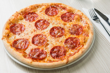 Detail of delicious salami pizza on the table