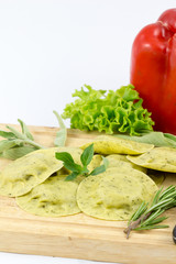 italian pasta ravioli with green herb on wood white background / homemade pasta ravioli and wooden with vintage mug of flour and fresh basil / fresh pasta ravioli 
