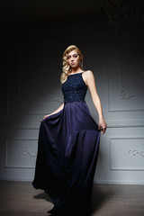 sexy blond woman in dark blue dress on chair