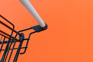 Fototapeta na wymiar Minimalism style, Shopping cart and orange wall.