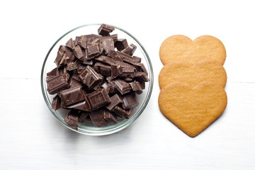 Chocolate chunks in a bowl with heart shaped gingerbread cookies