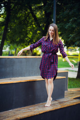 Girl does pirouette walking on a tiptoes against summer park.