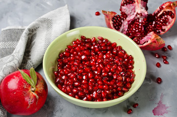 Red ripe pomegranate on gray concrete background