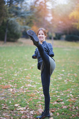Beautiful invalid young woman born without upper extremities, without arms exercising karate.