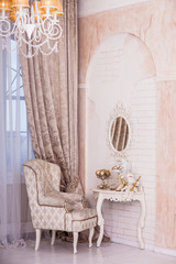 Classical interior design of living room, armchair, Christmas Santa sitting on the dressing table. Vertical